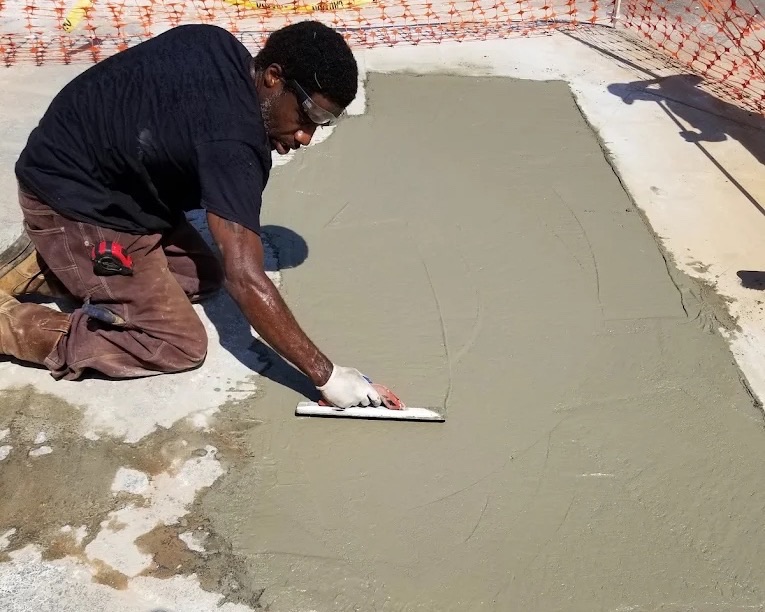 Technician finishing a repaired concrete slab at a commercial property